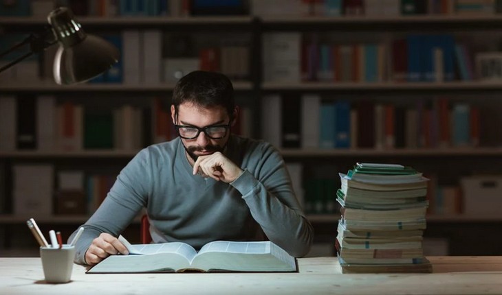 Seorang pria sedang mempelajari buku